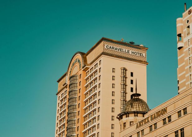 Low-angle view of Caravelle Hotel against a clear blue sky in Ho Chi Minh City.